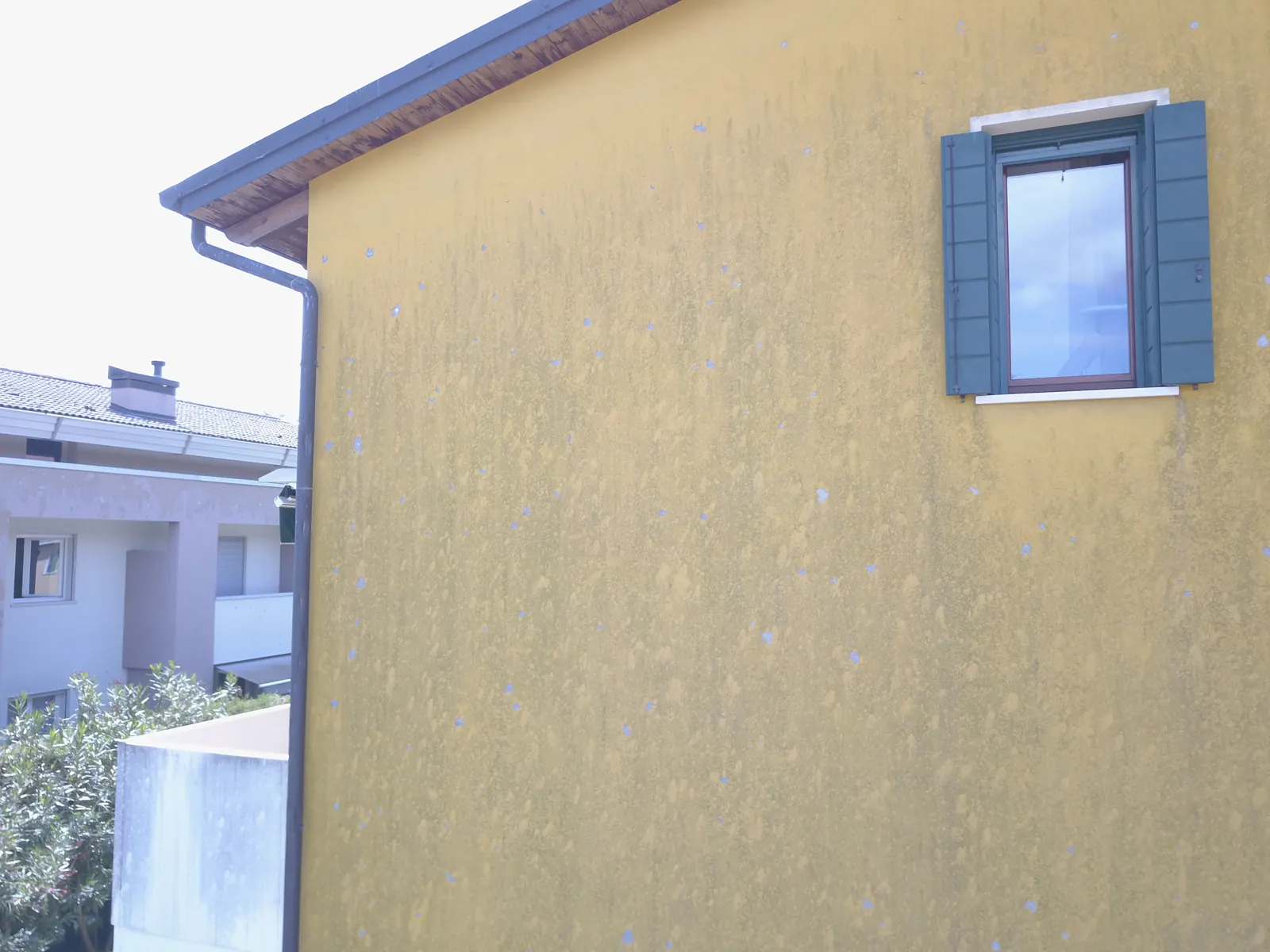 La facciata di una casa segnata dagli impatti della grandine