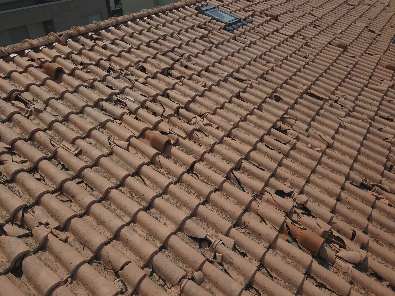 Tegole rotte dalla grandine su un tetto, viste dal drone
