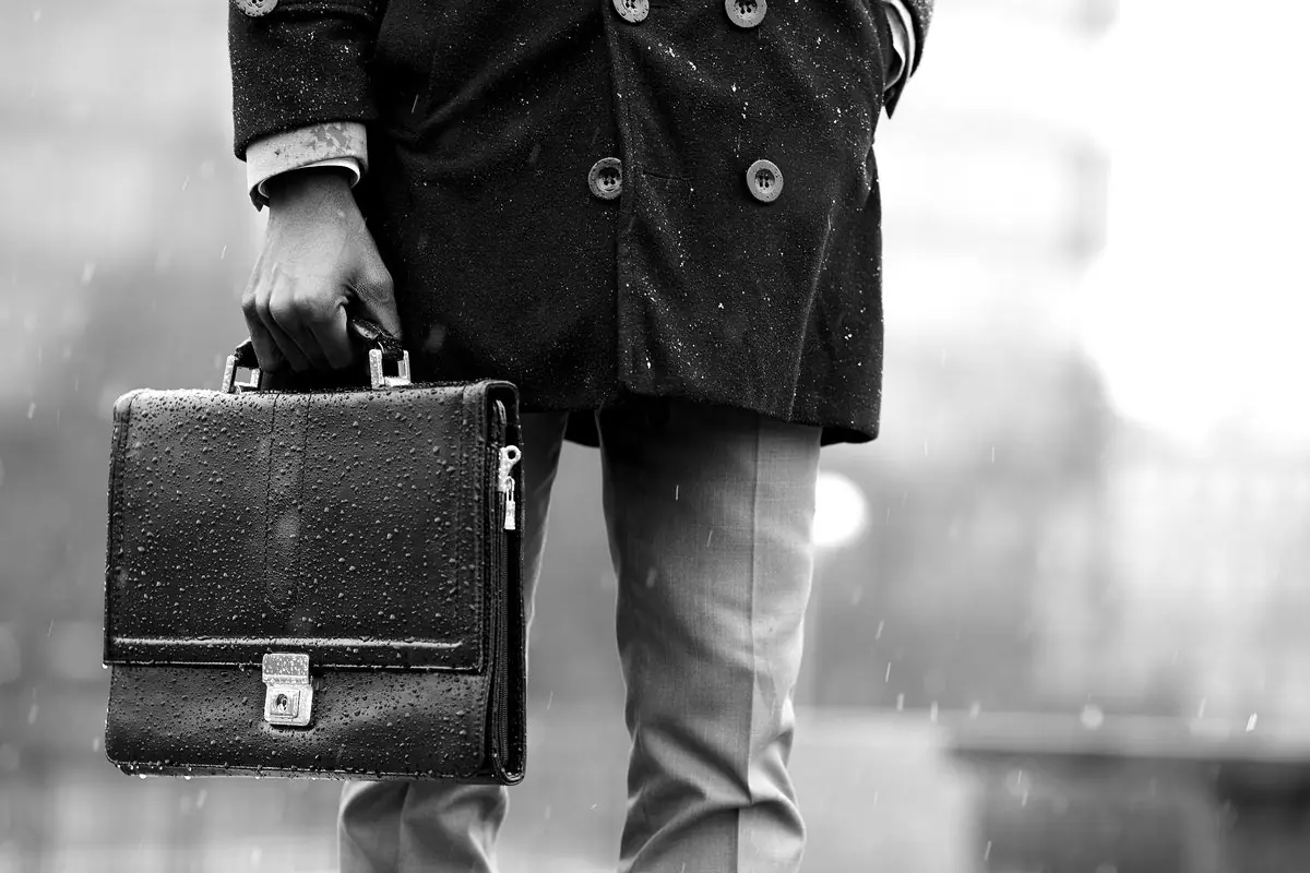 Un perito con la borsa sotto la pioggia