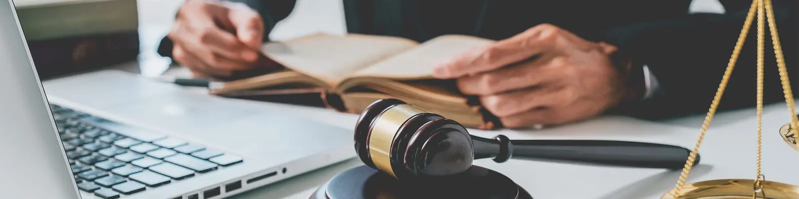 Un martelletto da giudice e un codice aperto su una scrivania