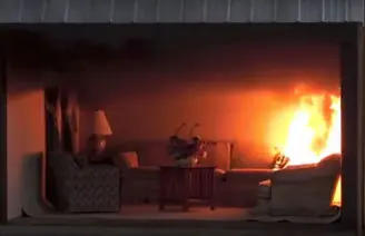 Le fiamme si estendono nel soggiorno mentre il fumo si accumula sotto il soffitto