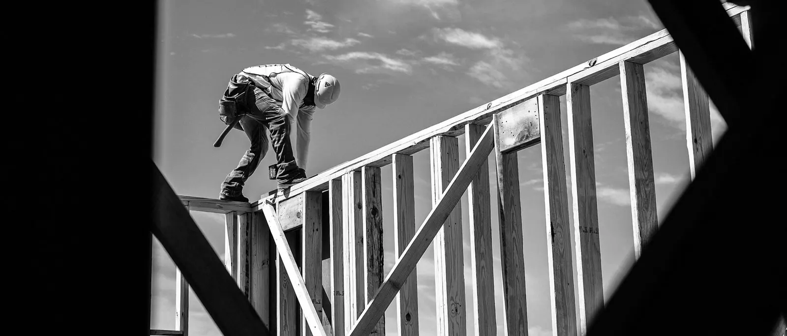 Un operaio al lavoro sulla struttura in legno di un tetto